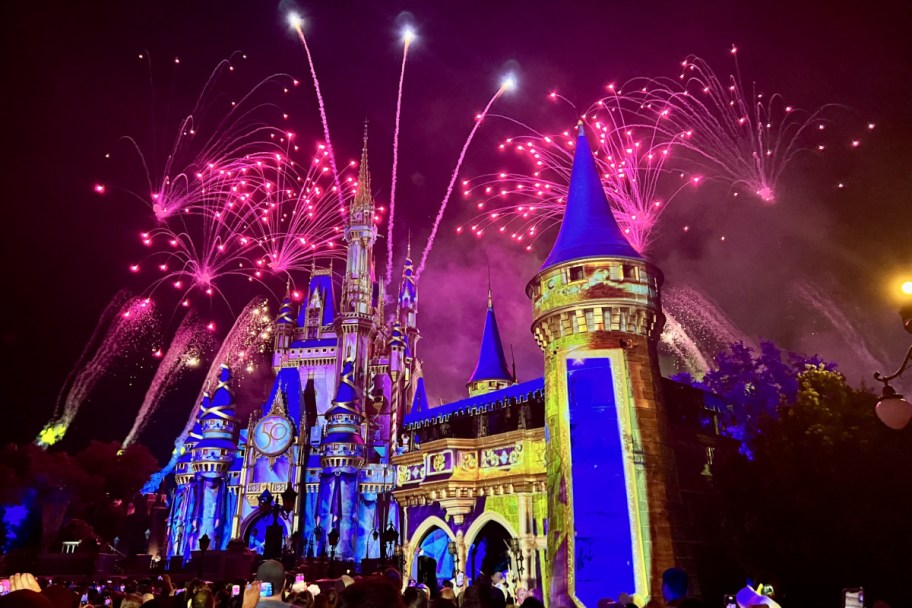 disney castle with fireworks behind it 