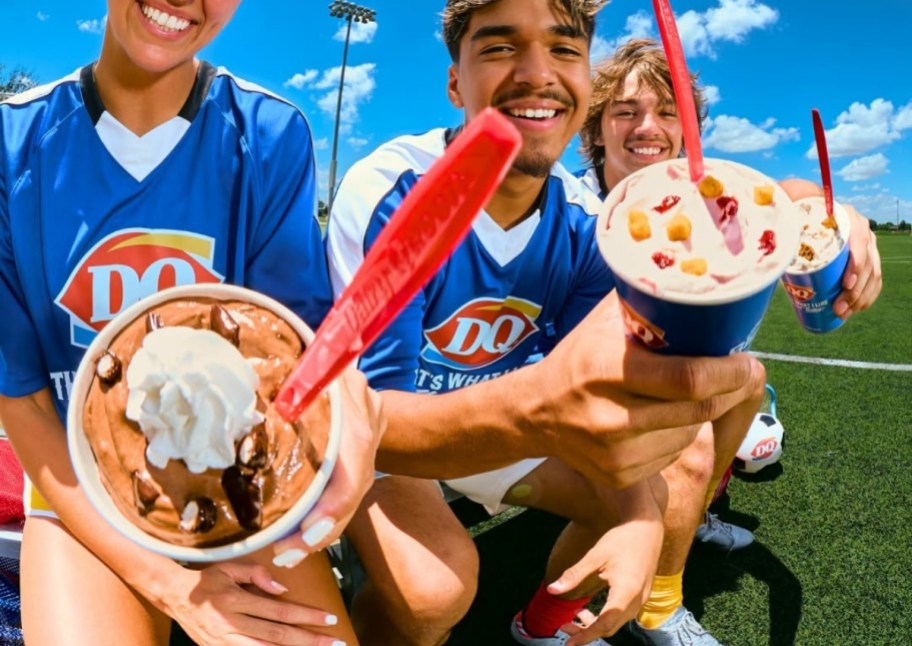 3 people on a. soccer field with blizzards