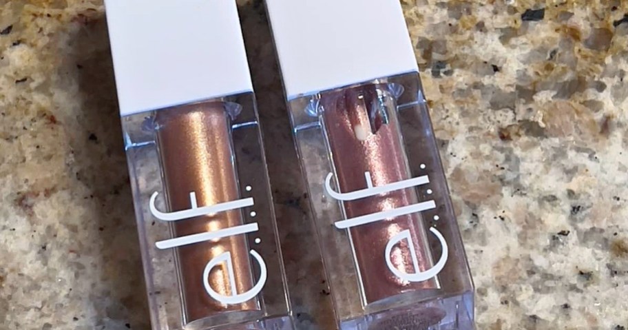 Two tubes of e.l.f. liquid metallic eyeshadow, one copper and one rose gold, resting on a speckled countertop.