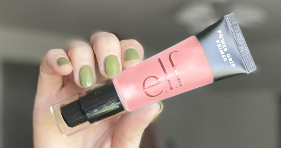 hand holding up a pink tube of elf primer