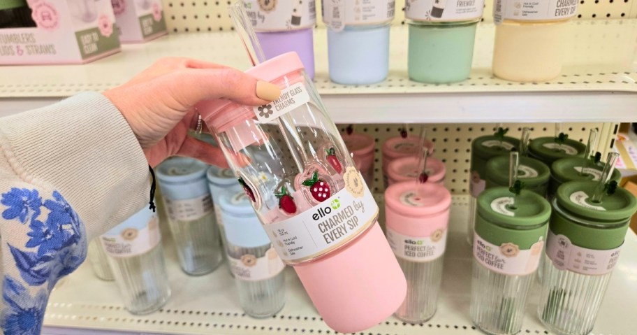 hand holding a pink and white glass tumbler with a strawberry print on it