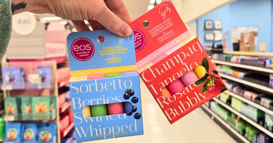 hand holding two packs of eos lip balms in a store