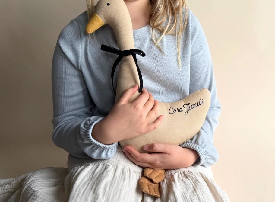 girl holding personalized name goose with black bow
