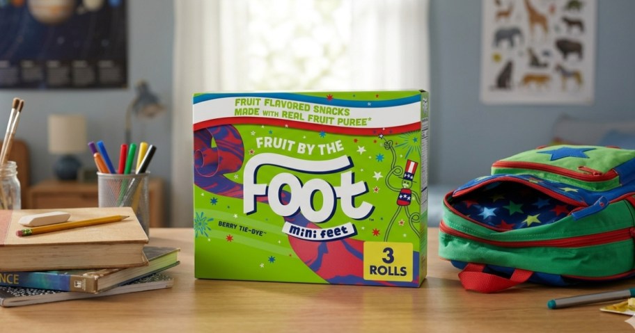 box of fruit snacks on a kids desk next to a backpack and books