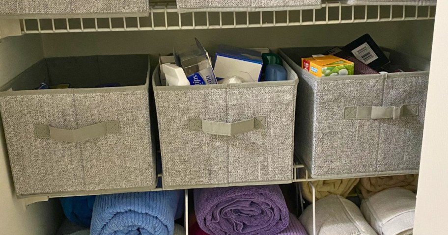 3 grey storage bins in a closet