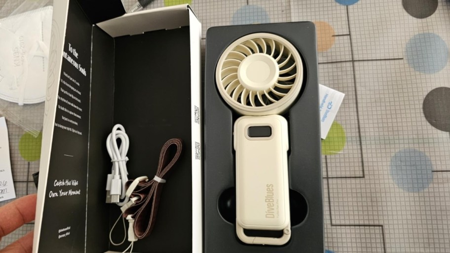 a small ivory colored personal fan in a box