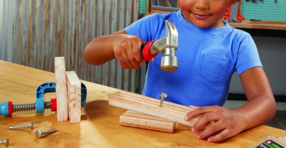 a girl playing with the hammer and nails from the little tikes construction haMMER AND NAILS SET