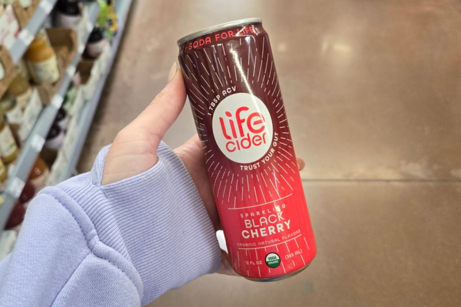 hand holding red soda can in store