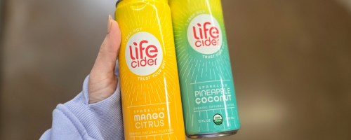 hand holding two cans of Life Cider drinks