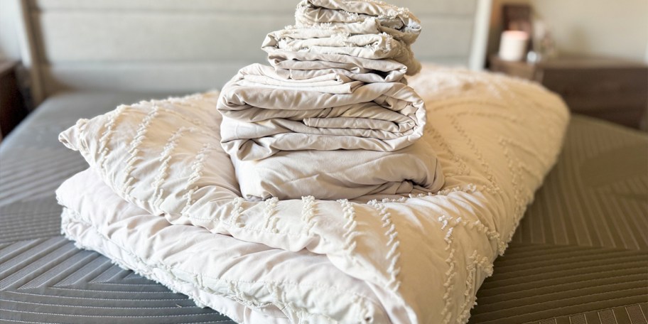 white bedding stacked on bed 