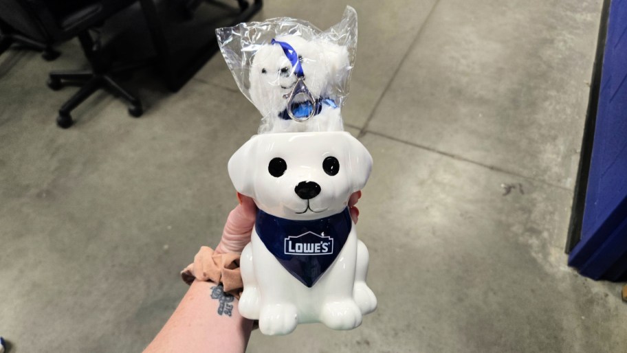 hand holding a ceramic puppy planter with a lowes bandana on it