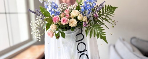 boy holding plastic bag with flowers sticking out