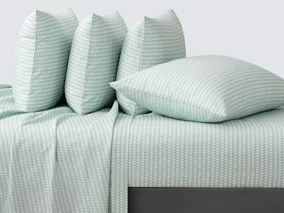 green and white sheet set on bed