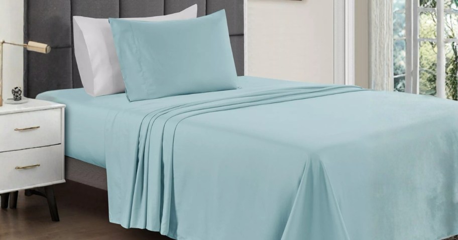 a twin bed with blue sheets on it