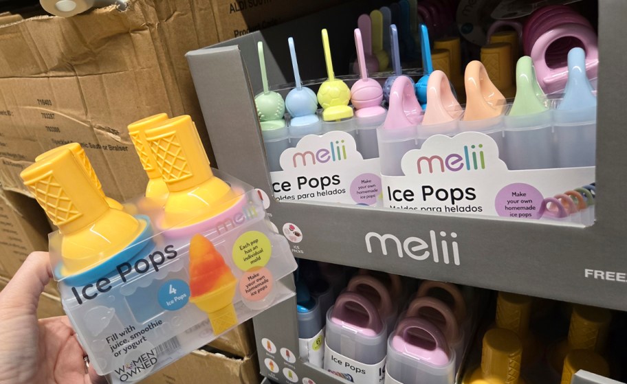 hand holding ice cream molds with more on shelf 