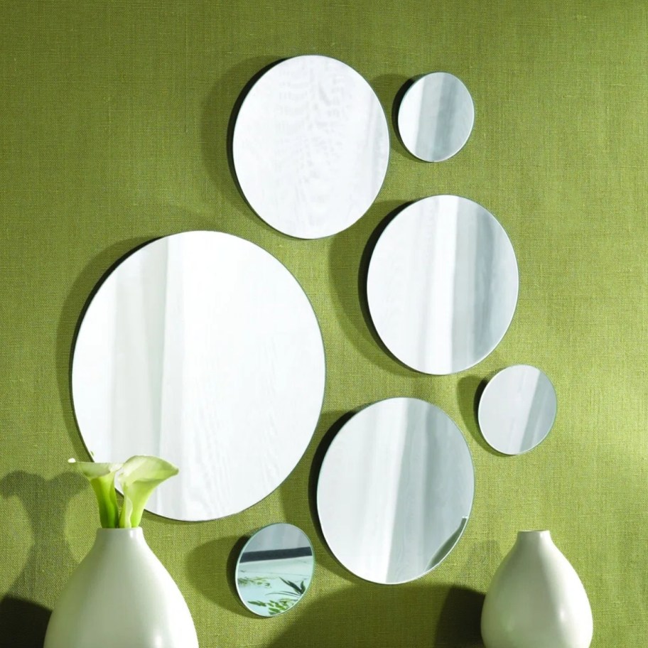 7 round mirror of varying sizes hanging in a grouping