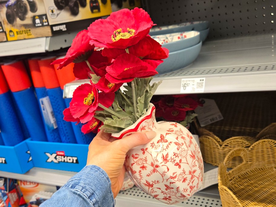 hand holding red floral vase 