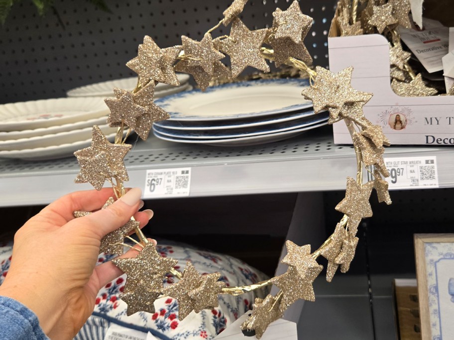 hand holding gold star wreath 