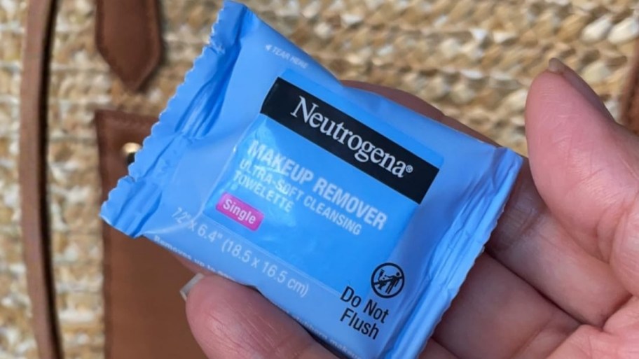 a woomans hand holding a single makeup removing cloth. 