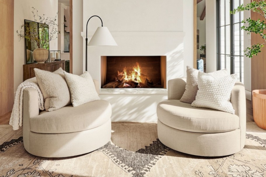 two light brown swivel chairs in front of fireplace