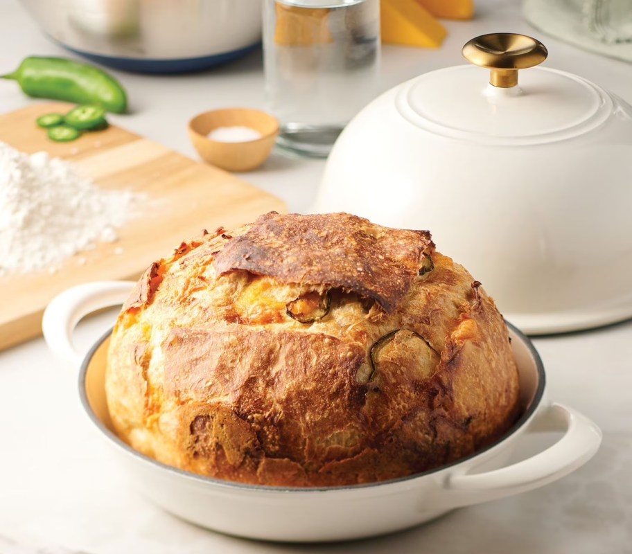 white dutch oven with loaf of bread sitting on kitchen counter