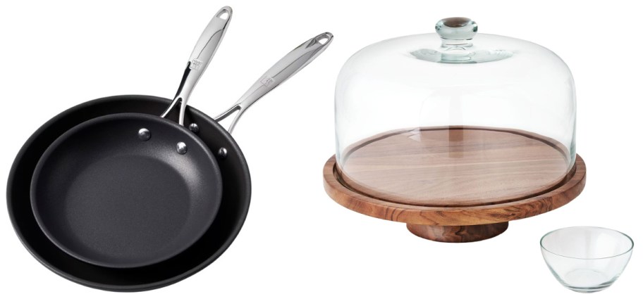 Two nonstick frying pans with silver handles beside a wooden cake stand with a glass dome. A small clear glass bowl is nearby.