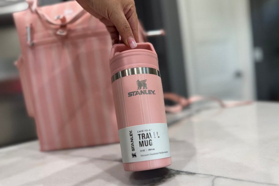 hand grabbing pink tumbler with handle lid