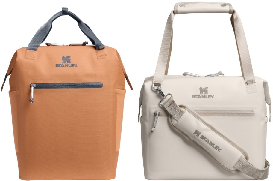 Two insulated coolers, one orange with gray handles and one cream with beige handles, both featuring the Stanley logo, sit side by side.