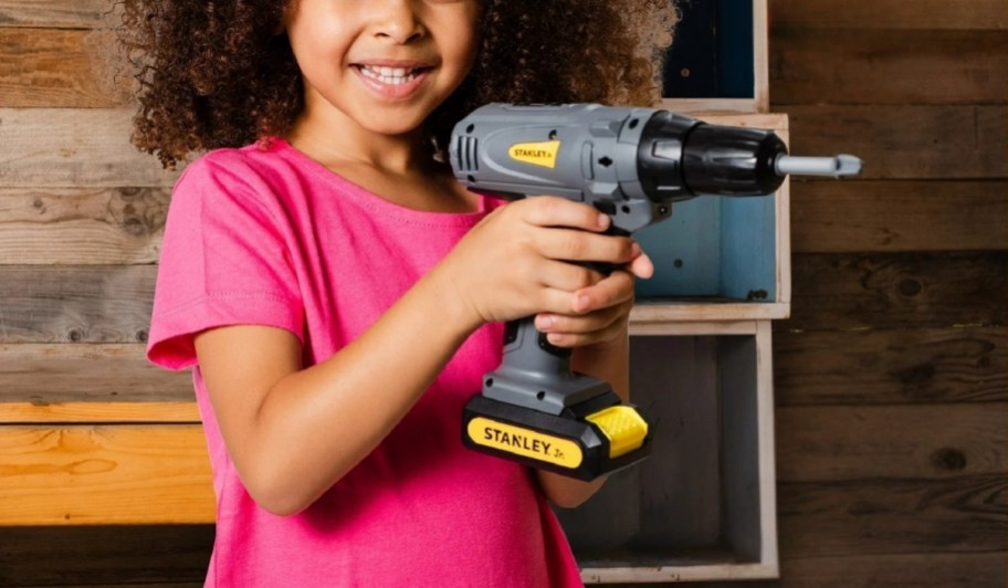 little girl using a toy drill.