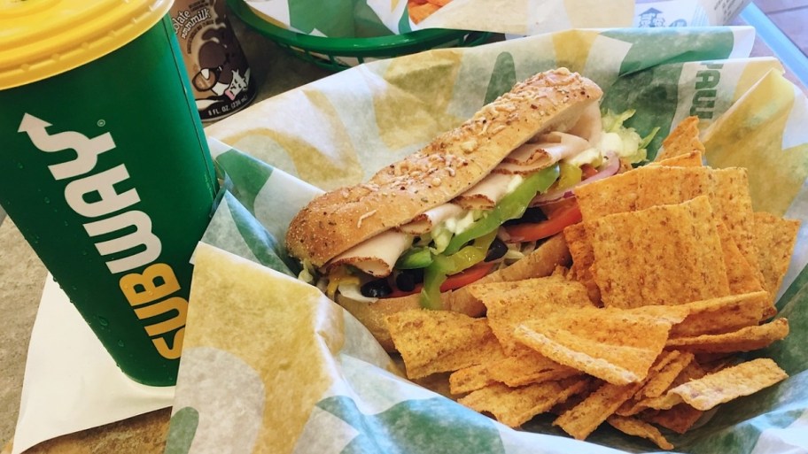 a subway sandwich sun chips and drink