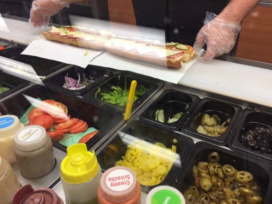 a subway sandwish being made in the store