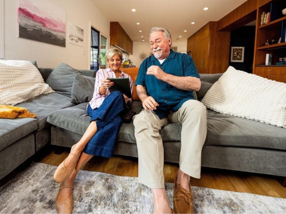 woman and man sitting on a sofa in a living room using an iPad