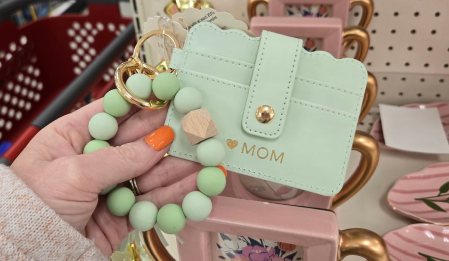 hand holding teal cardholder with beads