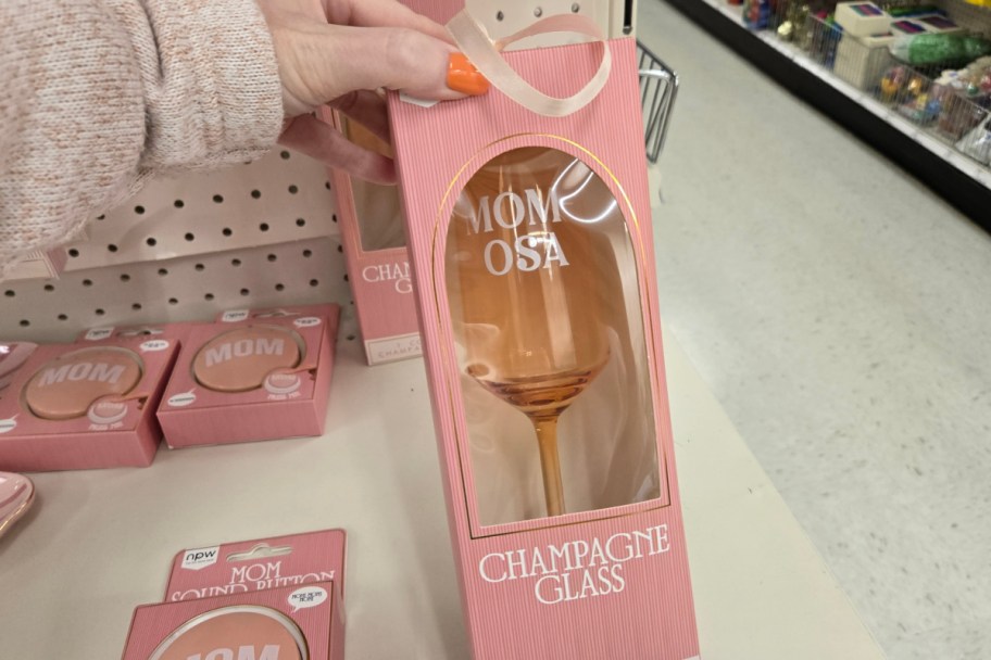 hand holding pink champagne glass in box