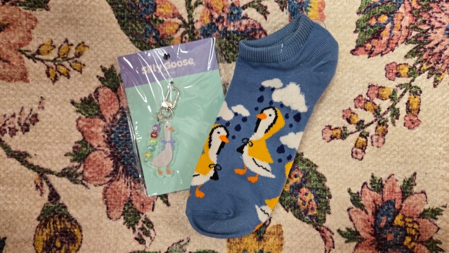 goose socks and keychain sitting on floral fabric