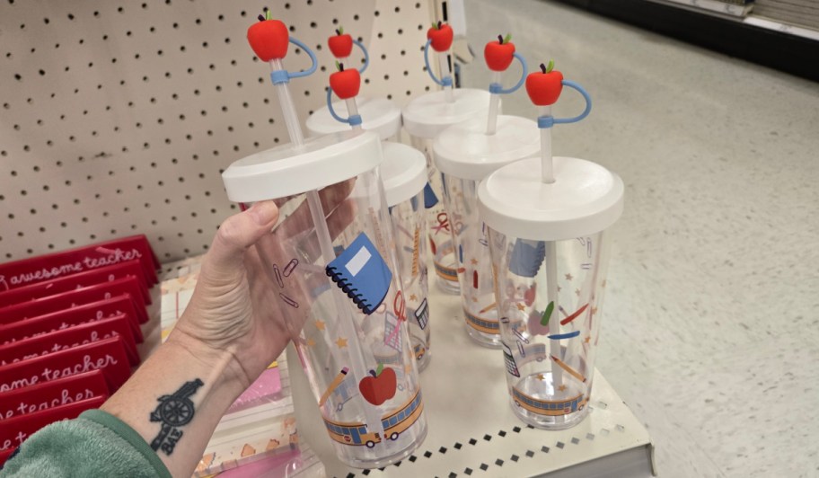 hand grabbing tumbler off shelf