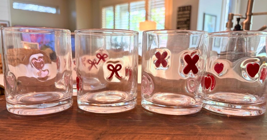 four Valentine's themed icon drink glasses on a table