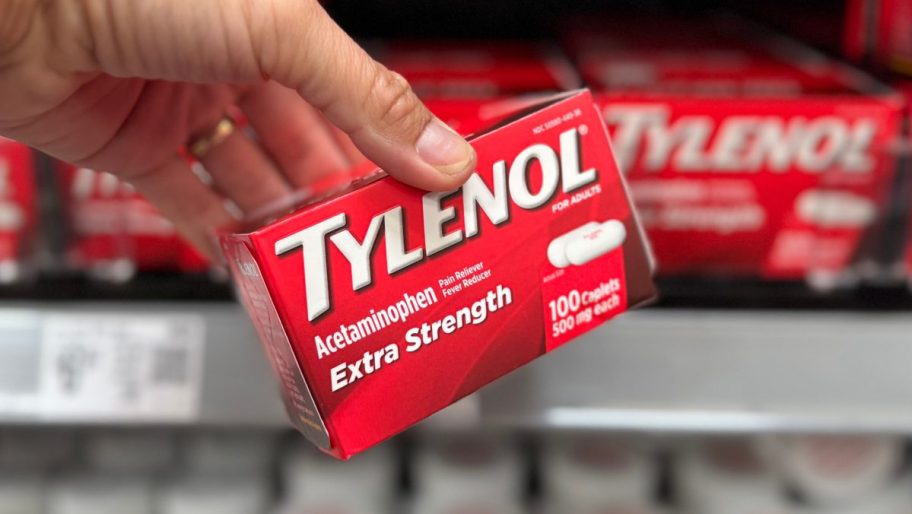 hand holding red box of medicine