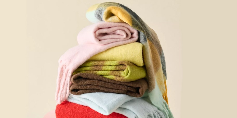 pink, yellow, green blankets stacked 