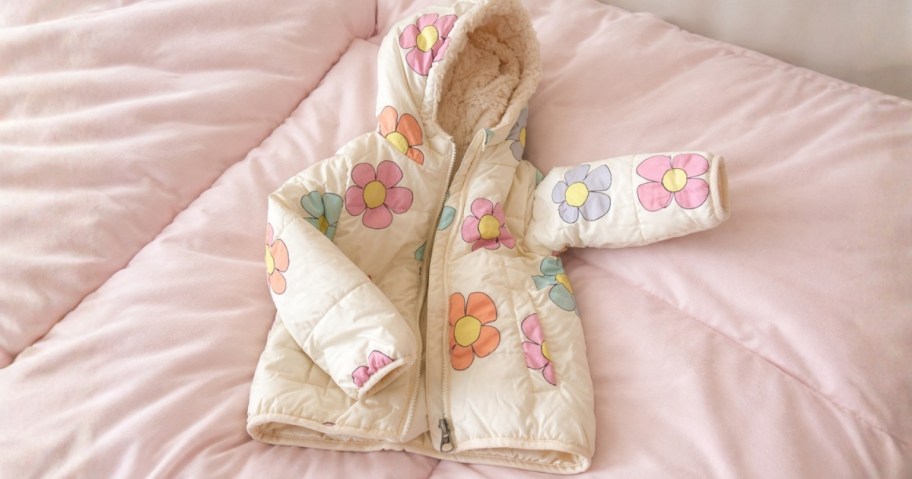 a kids floral jacket on a bed