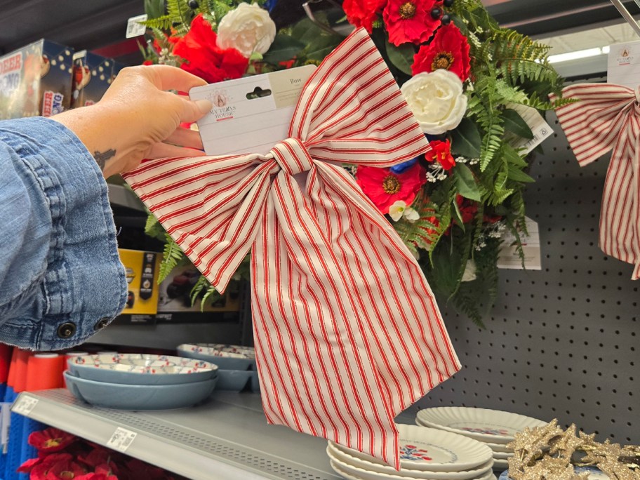hand holding white and red striped bow 