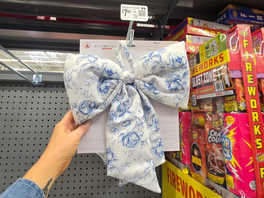 hand reaching for floral blue bow