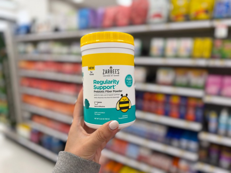 hand holding up a canister of zarbees fiber powder in a store aisle