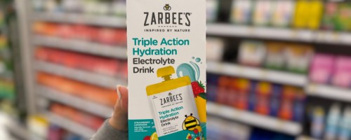 hand holding up a box of zarbees drink pouches in a store aisle