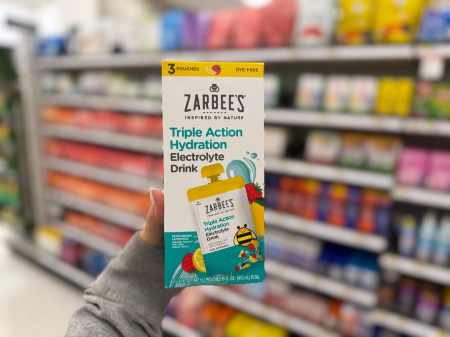 hand holding up a box of zarbees drink pouches in a store aisle