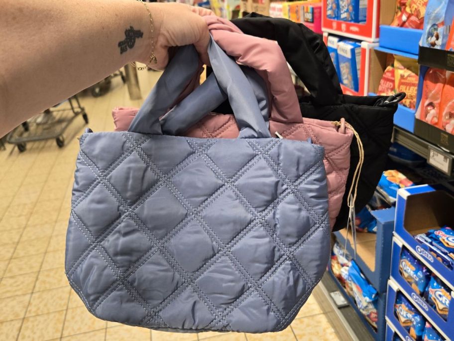 Hand holding small quilted bags from ALDI