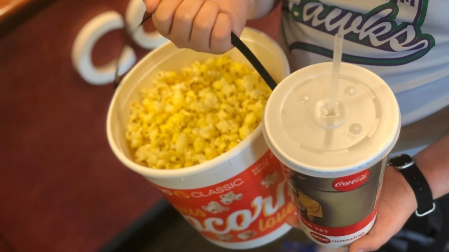 hands holding a drink and popcorn