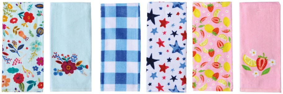 Six colorful kitchen towels are displayed vertically. Designs include floral patterns, blue checkered, stars, fruit motifs, and embroidered strawberries.