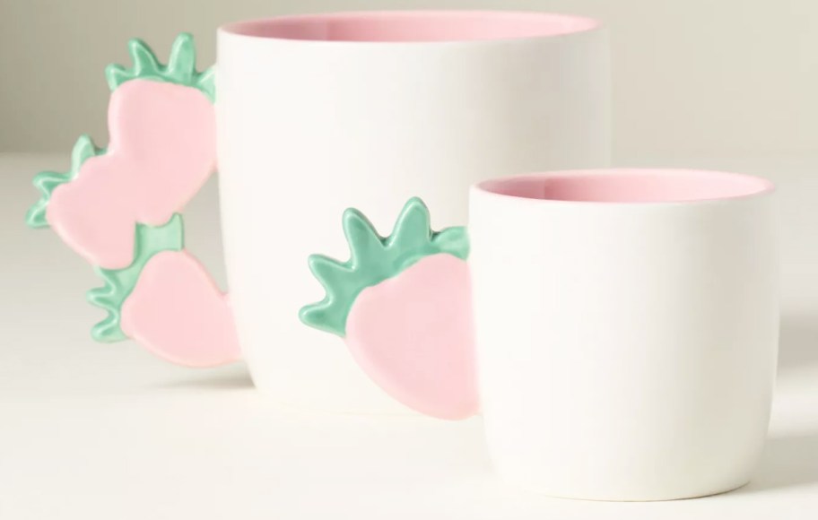 two white mugs with strawberry handles