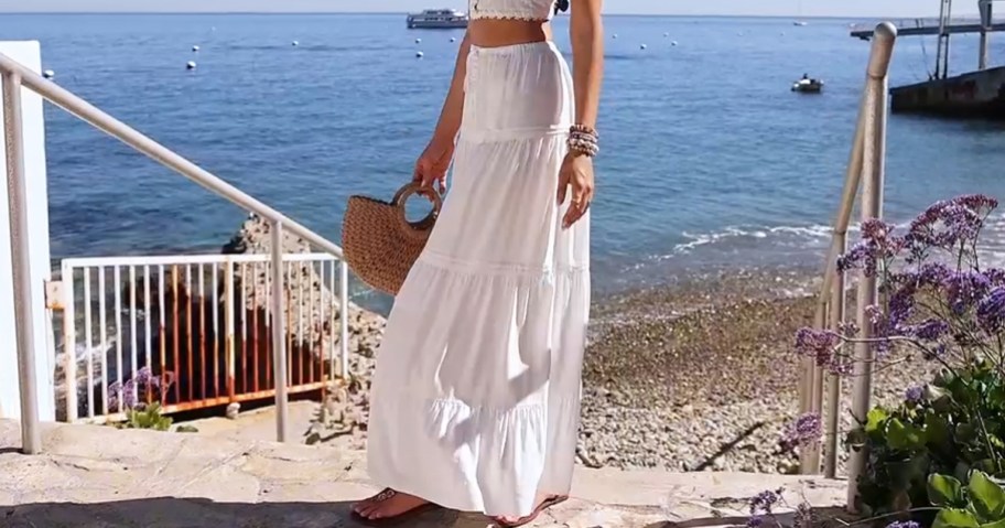 woman wearing a white maxi skirt and crop top near beach